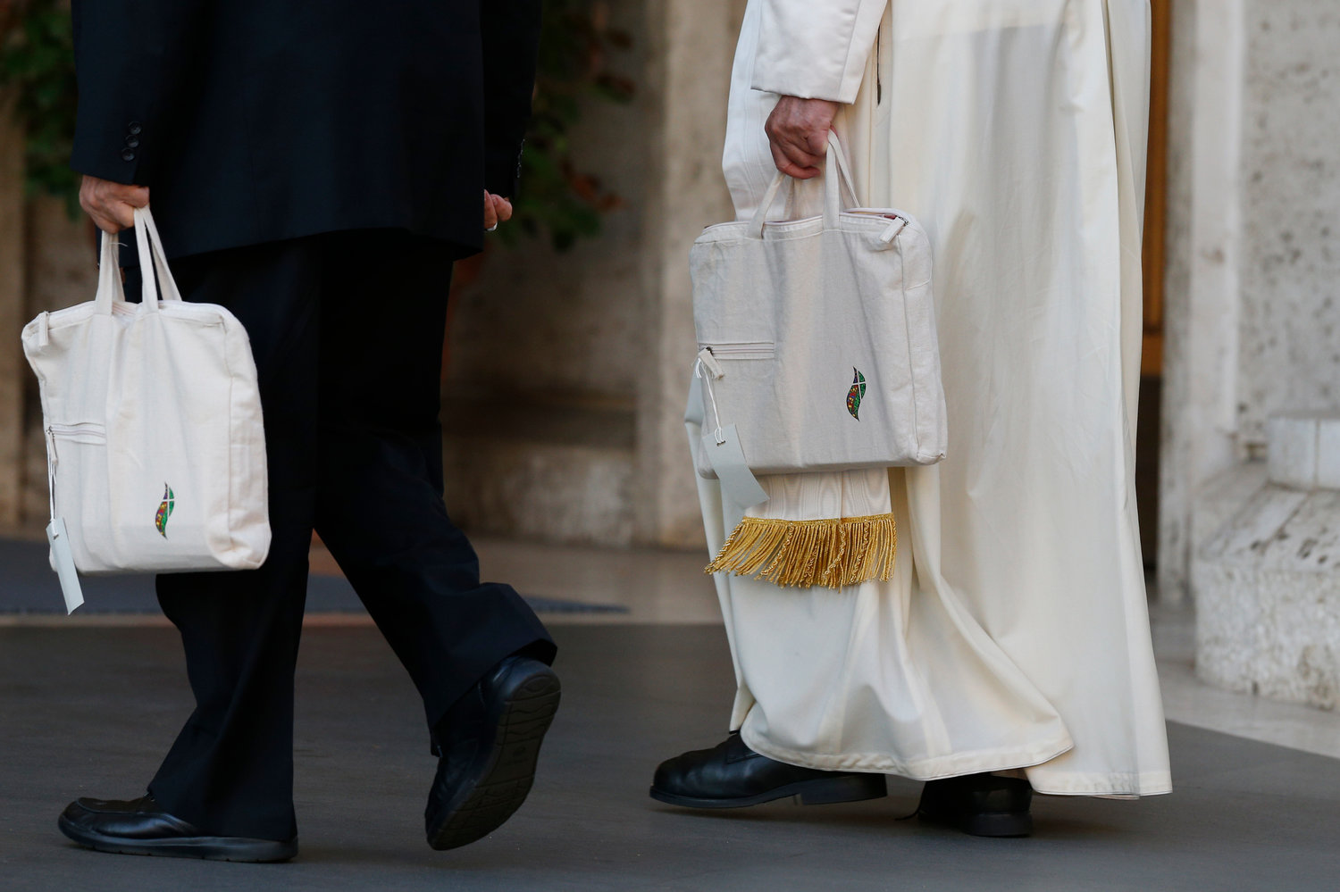 Pope Francis and Italian Bishop Marcello Semeraro of Albano carry their bags as they arrive for a session of the Synod of Bishops for the Amazon at the Vatican Oct. 15, 2019.